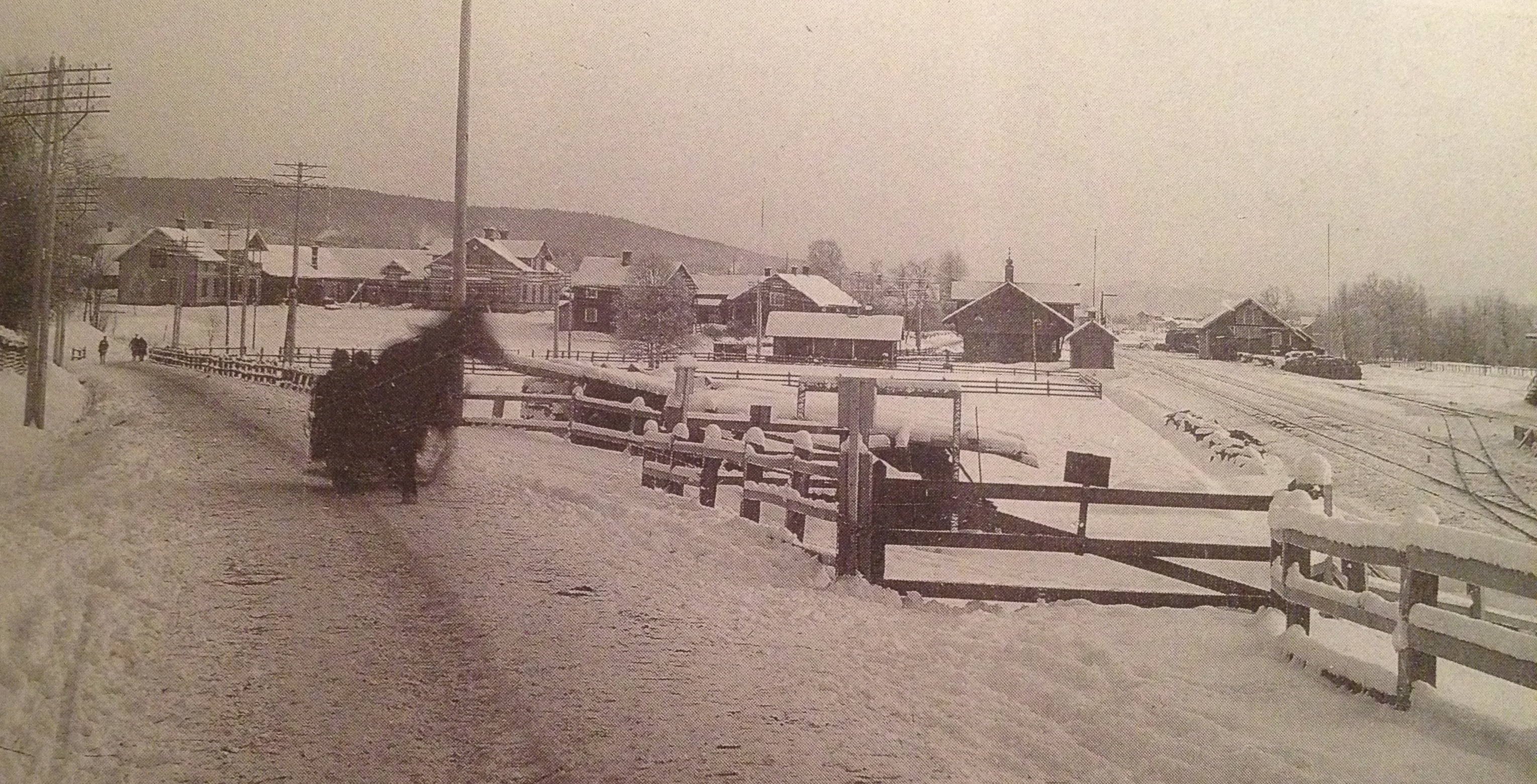 "Vy söderut mot Lassisgården och järnvägsstationen; t.h. kolbryggan (bortom lokstallet) där kolkörarna tömde sina kolryssar för vidare befordran. Foto C. Ehrner omkr. 1905." Bilden hämtad ur "Älvdalens kyrkby när seklet var ungt" av Helge Lindberg